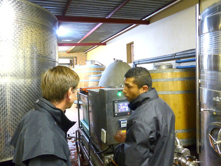 Philippe supervise un technicien en plein travail sur la récolte d'un viticulteur.
